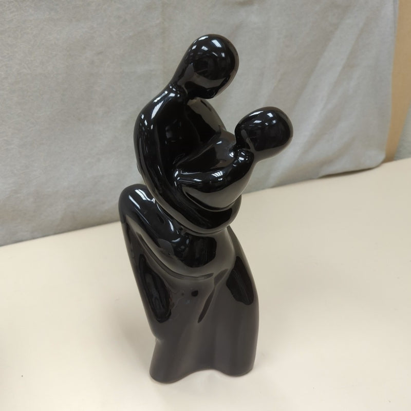 BLACK FIGURES EMBRACING STATUE