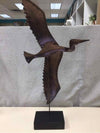 BROWN METAL BIRD ON WOOD STAND